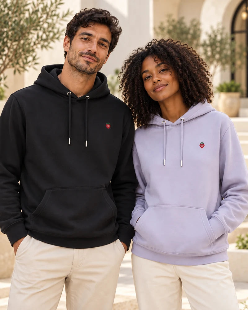 Two models wearing black and lavender hoodies with the signature embroidered heart